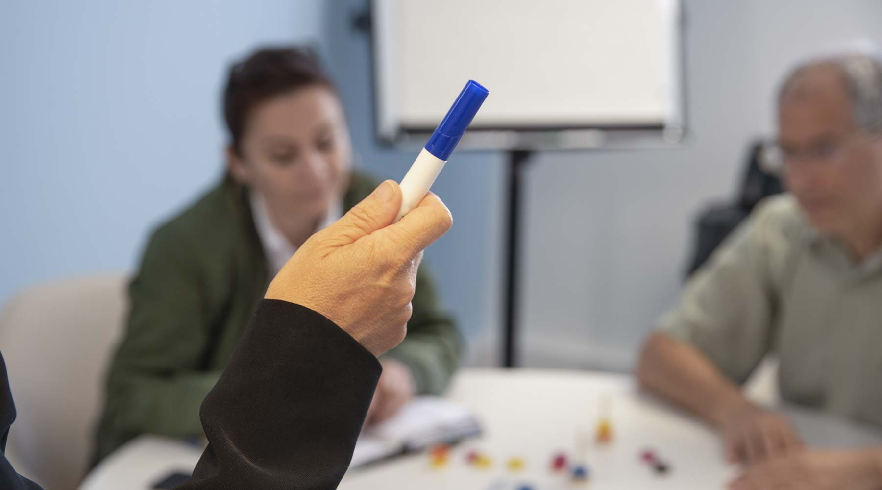 Gros plan sur la main de Laurence Fabre tenant un stylo pendant une séance de coaching